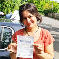 me in a car park holding a pass certificate